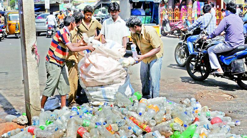 Civic staff remove plastic waste including bottles from an underground drainage line at Devi Chowk in Rajahmundry